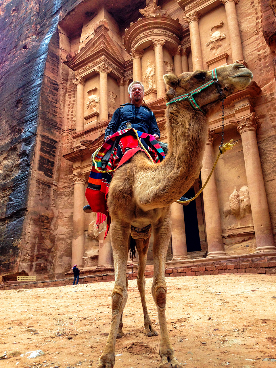 Astride a camel in front of the Treasury edifice in Petra Jordan