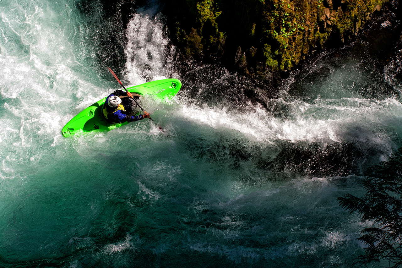 Downshot of whitewater kayaker navigating canyon rapids